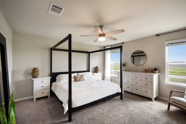 carpeted bedroom featuring baseboards, visible vents, and multiple windows