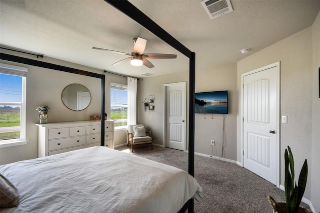 bedroom with a ceiling fan, a textured ceiling, visible vents, carpet floors, and baseboards