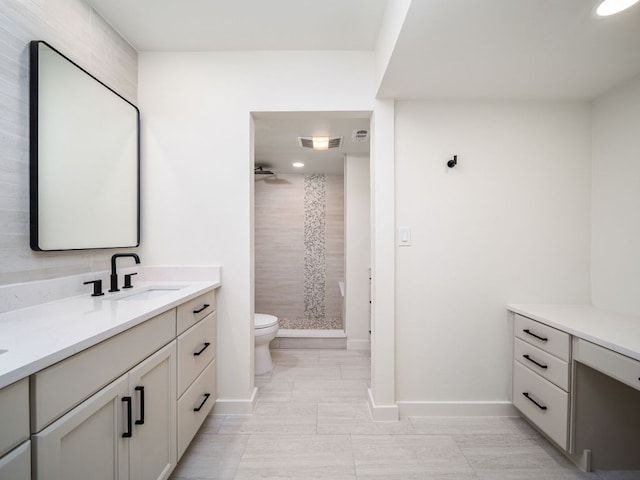 bathroom featuring visible vents, vanity, toilet, baseboards, and a shower stall