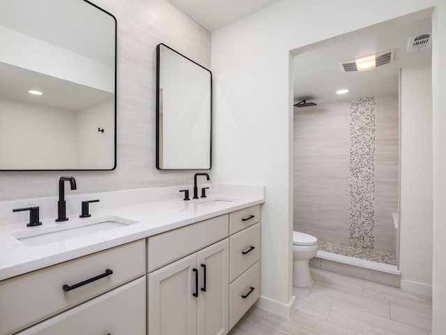 full bath with a sink, toilet, and visible vents