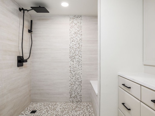 full bathroom with vanity, a tile shower, and recessed lighting