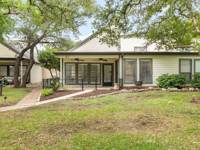 back of property with a lawn and a ceiling fan