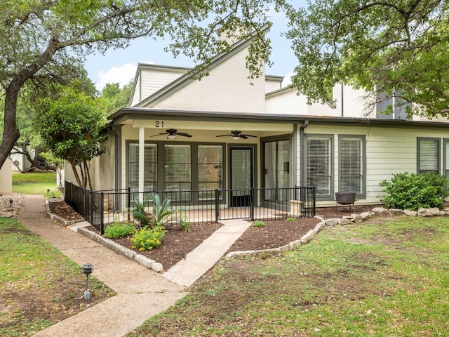 rear view of house featuring ceiling fan and a patio area