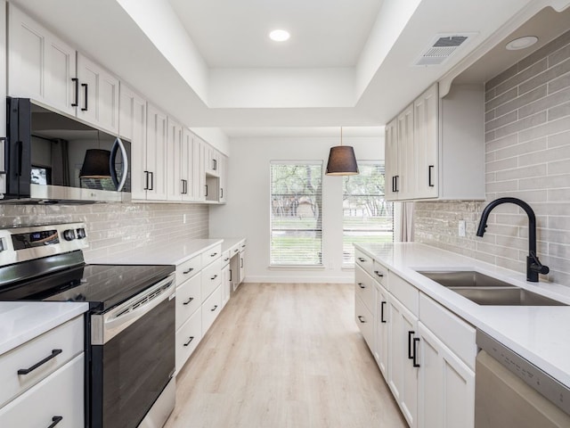 kitchen with a sink, tasteful backsplash, stainless steel appliances, and visible vents