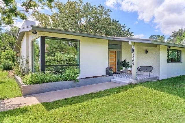 doorway to property featuring a yard and a porch