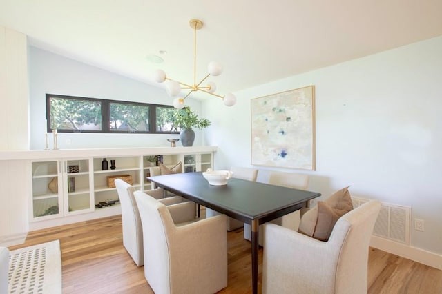 dining space with visible vents, vaulted ceiling, light wood-type flooring, and a notable chandelier
