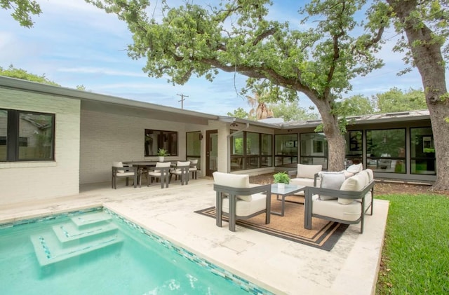 back of house featuring an outdoor pool, a sunroom, an outdoor hangout area, a patio, and outdoor dining space