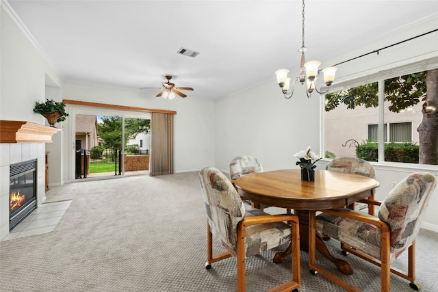 508 Texas Dr, Georgetown, TX 78633 - dining space featuring visible vents, crown molding, a fireplace, light colored carpet, and ceiling fan with notable chandelier