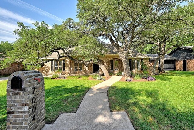 view of front of home with brick siding and a front yard
