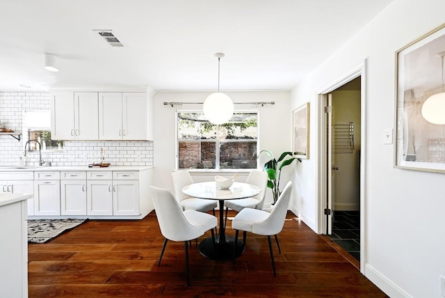 dining space with baseboards, dark wood-style flooring, and visible vents
