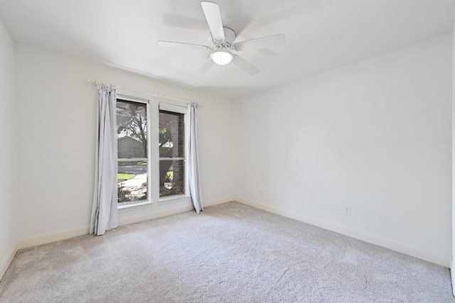 spare room with a ceiling fan, carpet flooring, and baseboards