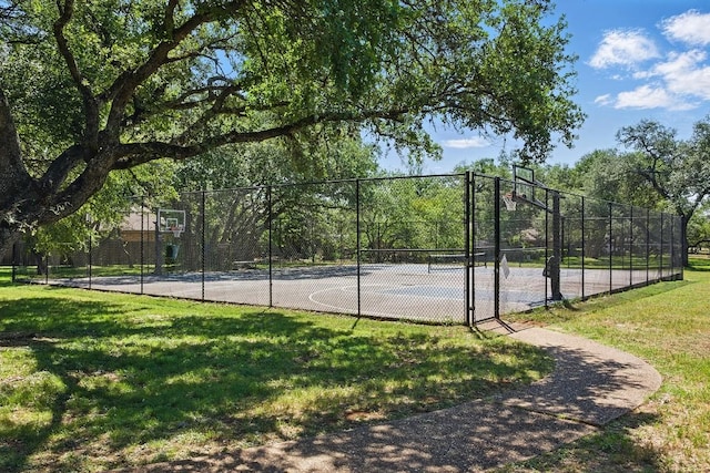 view of basketball court featuring a yard, fence, and community basketball court