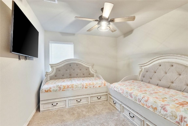carpeted bedroom with ceiling fan and baseboards