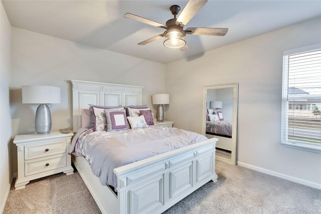 bedroom with baseboards, light colored carpet, multiple windows, and ceiling fan