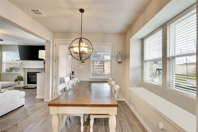 dining room featuring visible vents, light wood-style floors, a chandelier, and a wealth of natural light