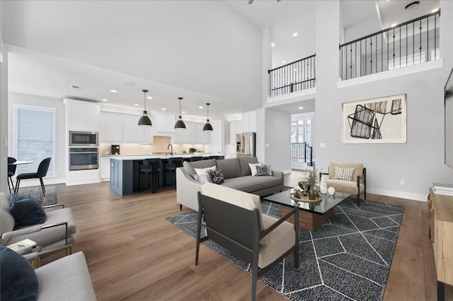 1400 Mulberry Oak Ln, Georgetown, TX 78628 - living room with wood finished floors, baseboards, a high ceiling, and recessed lighting