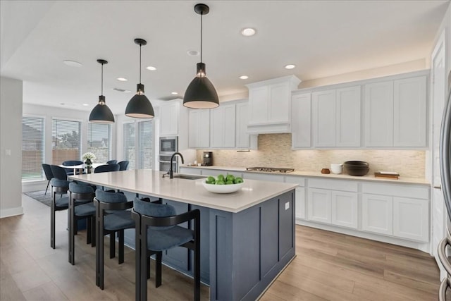 1400 Mulberry Oak Ln, Georgetown, TX 78628 - kitchen featuring a sink, stainless steel appliances, light countertops, white cabinets, and light wood finished floors