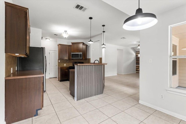 kitchen featuring visible vents, decorative backsplash, ceiling fan, stainless steel microwave, and light tile patterned floors