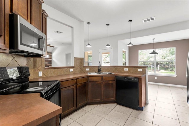 kitchen featuring visible vents, a sink, light tile patterned floors, and black appliances