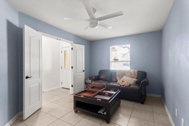 living room with a ceiling fan, baseboards, and light tile patterned flooring