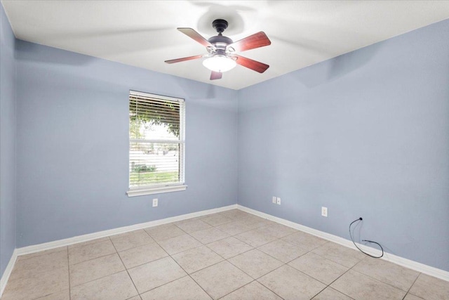 spare room featuring a ceiling fan, baseboards, and light tile patterned flooring