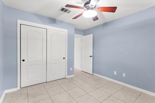 unfurnished bedroom featuring a ceiling fan, visible vents, light tile patterned floors, baseboards, and a closet
