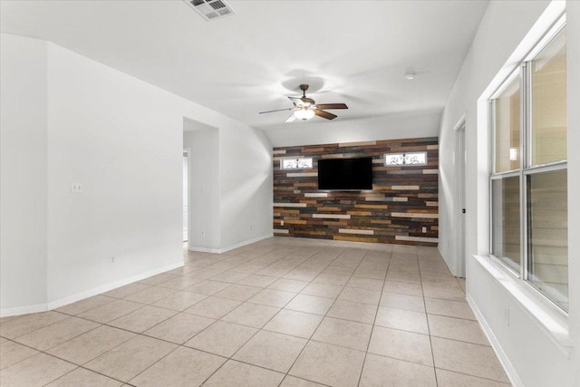 unfurnished living room featuring a ceiling fan, baseboards, visible vents, and light tile patterned floors