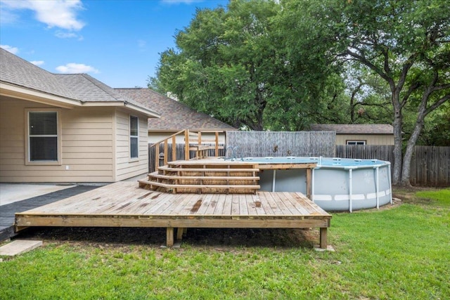 wooden terrace featuring a lawn, fence, and a fenced in pool