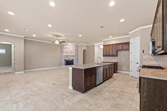 kitchen with ceiling fan, appliances with stainless steel finishes, arched walkways, a sink, and recessed lighting