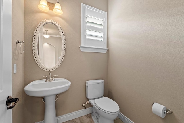 bathroom with toilet and baseboards