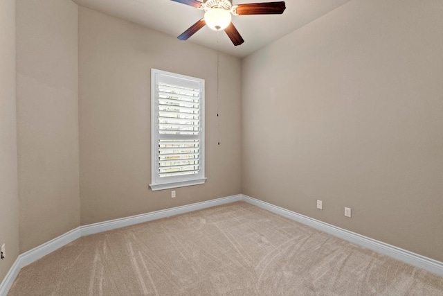 carpeted empty room featuring ceiling fan and baseboards