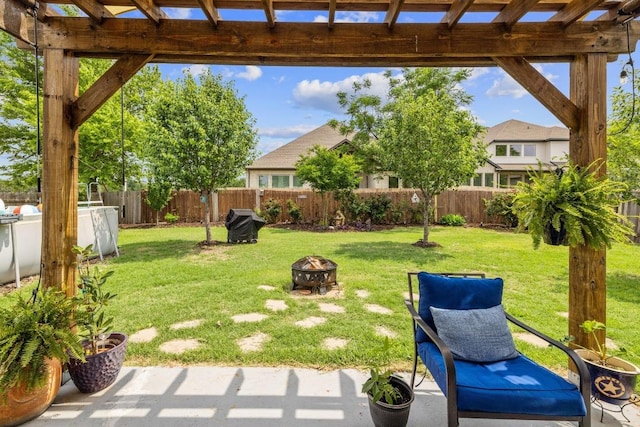 view of yard with a fenced backyard, a pergola, and an outdoor fire pit
