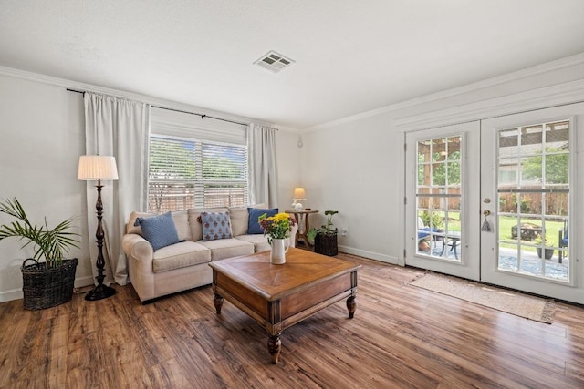 living room with ornamental molding, visible vents, plenty of natural light, and french doors