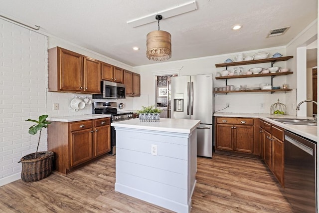 kitchen featuring open shelves, a sink, appliances with stainless steel finishes, and light countertops