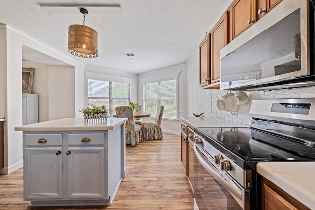kitchen with visible vents, light wood-style floors, light countertops, appliances with stainless steel finishes, and gray cabinetry
