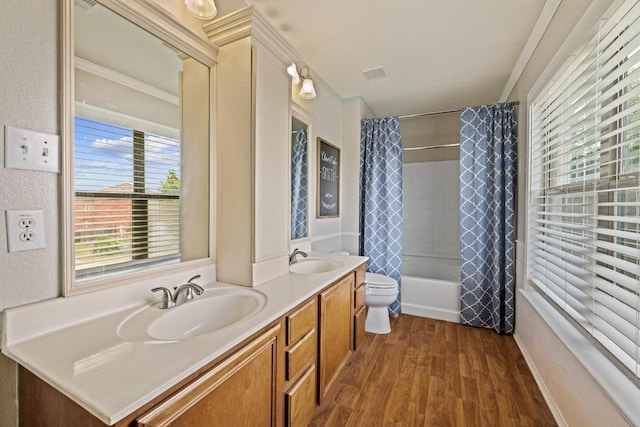 bathroom featuring double vanity, visible vents, a sink, and wood finished floors