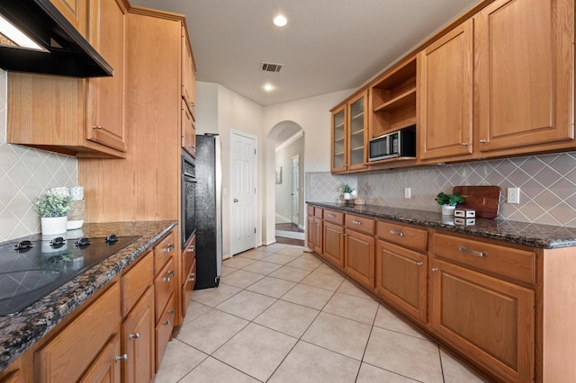12401 Fairfax Ridge Pl, Austin, TX 78738 - kitchen featuring visible vents, arched walkways, light tile patterned floors, black appliances, and under cabinet range hood