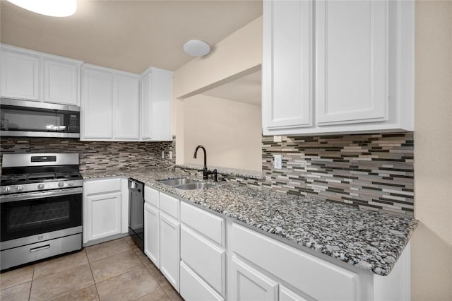kitchen featuring backsplash, white cabinets, appliances with stainless steel finishes, and a sink
