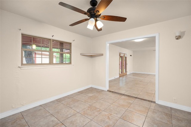 empty room featuring a ceiling fan, baseboards, and light tile patterned floors