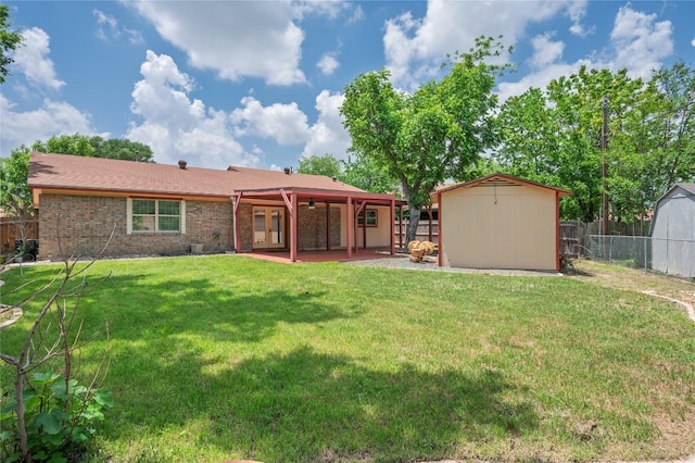 rear view of property featuring a storage shed, a yard, an outbuilding, and a fenced backyard