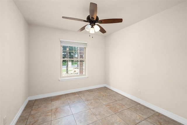 spare room featuring a ceiling fan, baseboards, and light tile patterned flooring