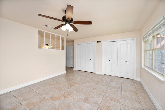 unfurnished bedroom with visible vents, baseboards, two closets, and light tile patterned flooring