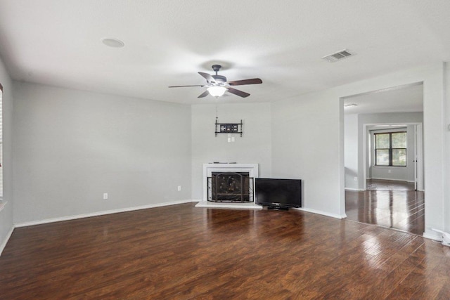 unfurnished living room with baseboards, ceiling fan, visible vents, and wood finished floors