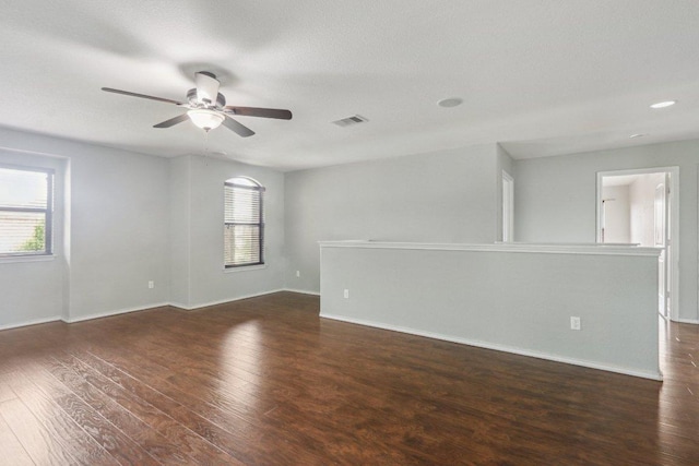 unfurnished room with a ceiling fan, baseboards, visible vents, and wood finished floors