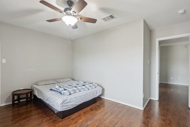 bedroom featuring baseboards, a ceiling fan, wood finished floors, and visible vents