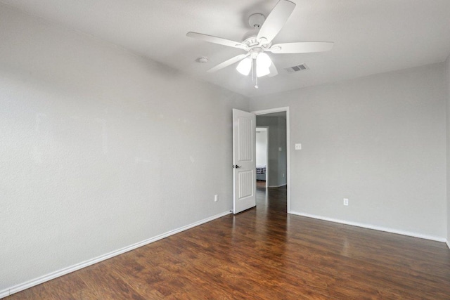 empty room featuring ceiling fan, baseboards, visible vents, and wood finished floors