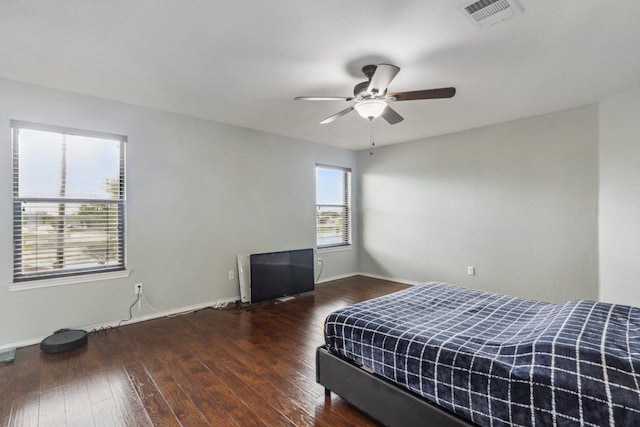 bedroom featuring a ceiling fan, baseboards, visible vents, and wood finished floors