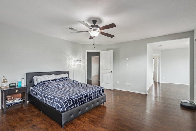 bedroom featuring baseboards, a ceiling fan, wood finished floors, and visible vents