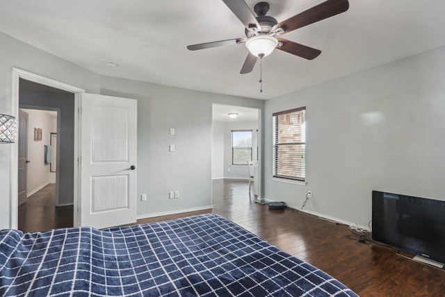 unfurnished bedroom with a ceiling fan, baseboards, and wood finished floors