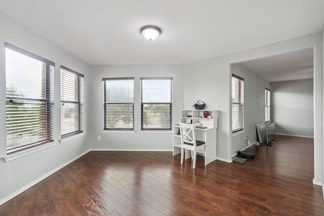 unfurnished room with baseboards and wood finished floors